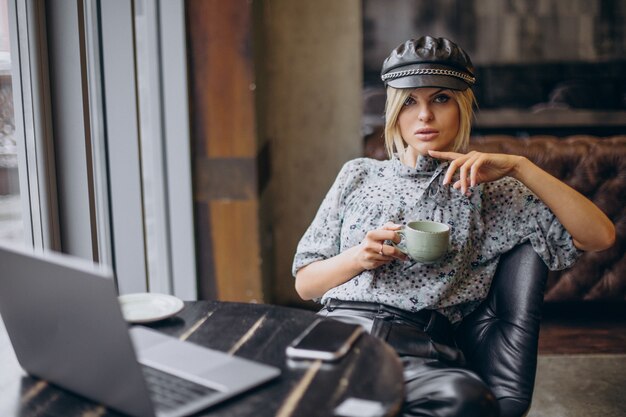 Mujer que trabaja en la computadora y tomando café