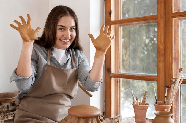 Foto gratuita mujer que trabaja en un lugar de trabajo de alfarería