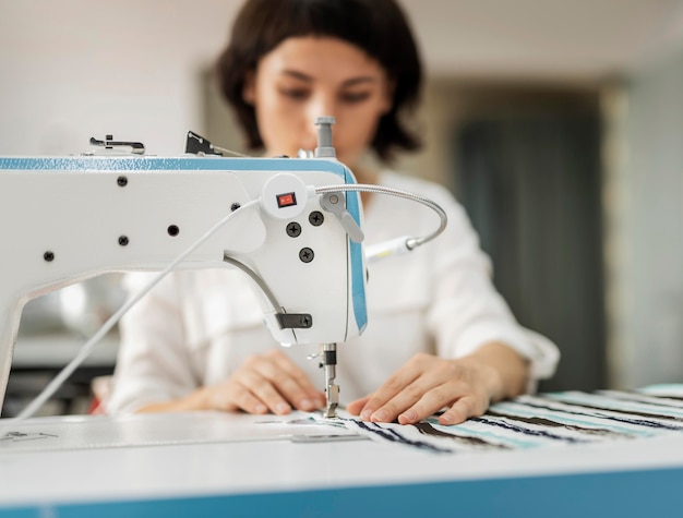 Mujer que trabaja en la máquina de coser