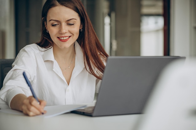 Foto gratuita mujer que trabaja en la oficina en una computadora