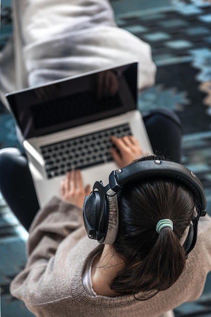 Una mujer que trabaja sentada en la vista superior de una computadora portátil