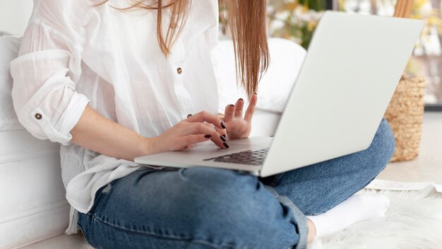 Mujer que trabaja con su computadora portátil en su regazo