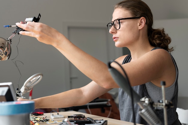 Foto gratuita mujer que trabaja en su taller para una invención creativa