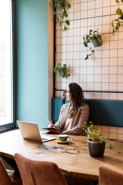 Foto gratuita mujer que trabaja con tableta de tiro medio