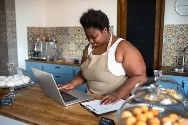 Mujer que trabaja con la vista lateral de la computadora portátil