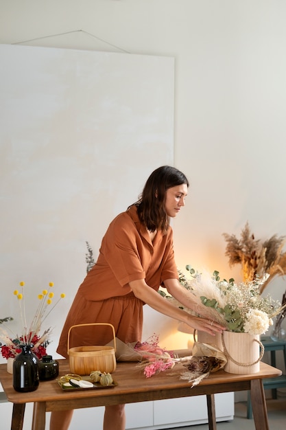 Mujer que trabaja con vista lateral de flores