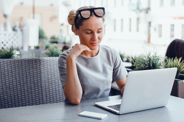 Mujer que usa la computadora portátil en un café