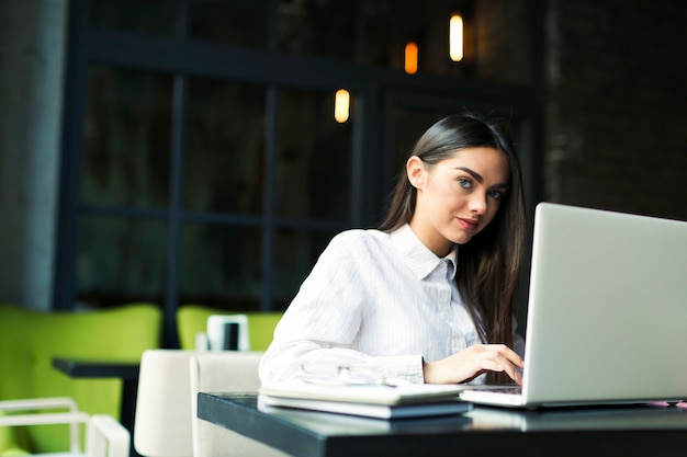 Mujer que usa la computadora portátil en café