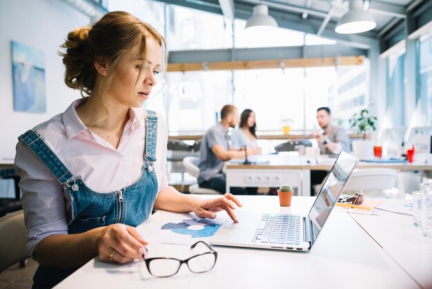 Mujer que usa la computadora portátil en la oficina