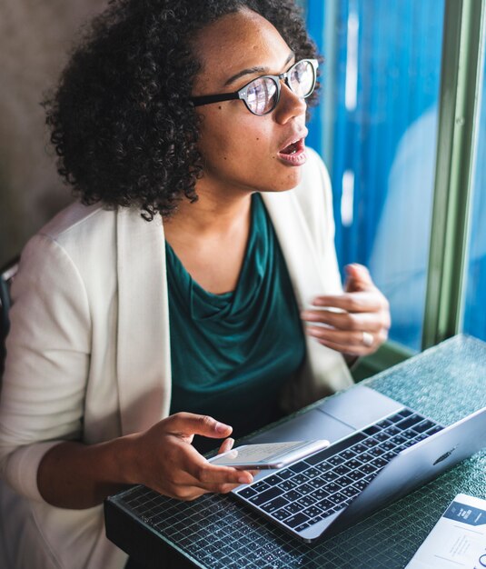 Mujer que usa dispositivos digitales en un café