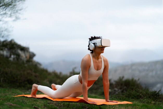 Mujer que usa gafas vr para hacer ejercicio al aire libre en la naturaleza