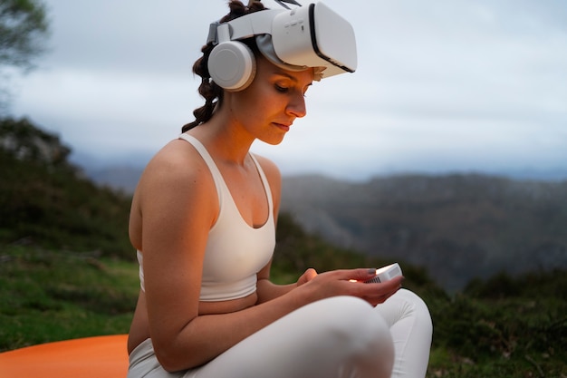 Foto gratuita mujer que usa gafas vr para hacer ejercicio al aire libre en la naturaleza