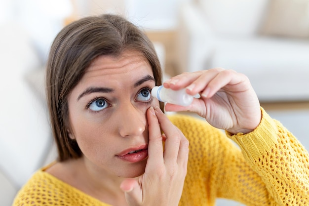 Mujer que usa gotas para los ojos mujer que deja caer lubricante para los ojos para tratar el ojo seco o la alergia