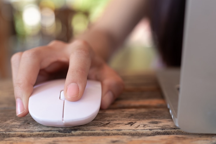 Foto gratuito mujer que usa el ratón del ordenador con la computadora portátil.