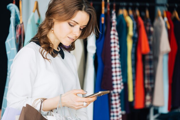 Mujer que usa smarthone en la tienda