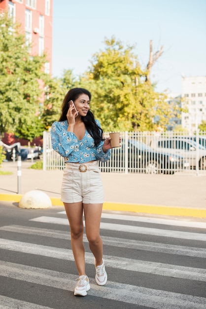 Mujer que usa su teléfono con fondo urbano