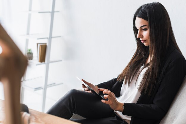 Mujer que usa la tableta en la oficina