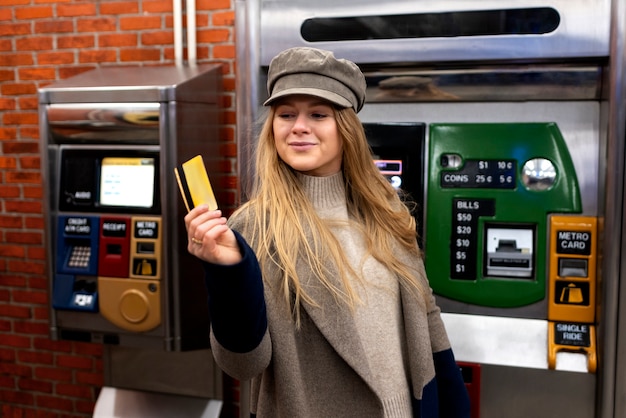 Mujer que usa una tarjeta de metro para viajar con el metro en la ciudad