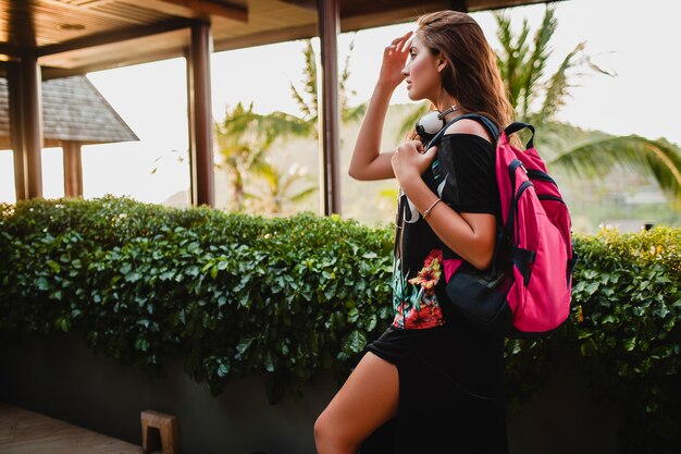 Mujer que viaja con una mochila en villa tropical