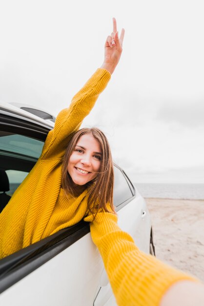 Mujer que viaja tomando un selfie en coche