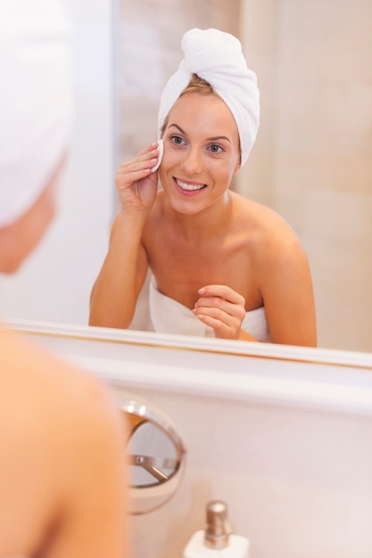 Mujer quitando el maquillaje de la cara