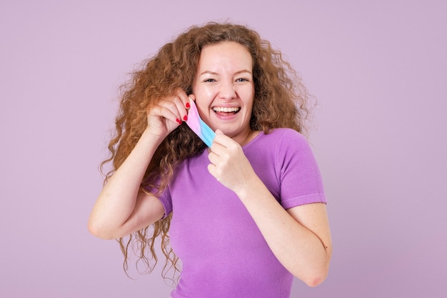 Mujer quitándose la máscara de la maqueta durante la nueva normalidad