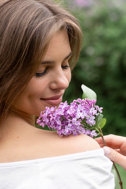 Foto gratuita mujer con rama flor lila