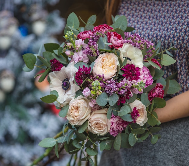 Una mujer con un ramo de flores rosas y blancas en la mano