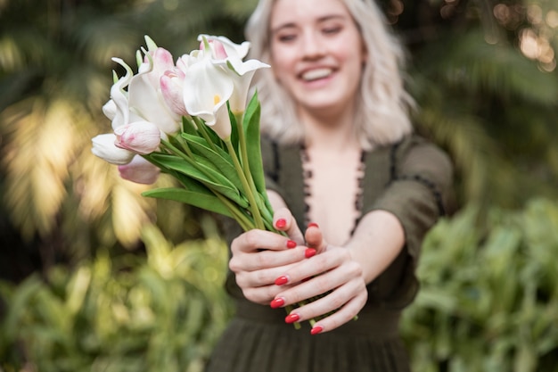 Mujer con ramo de flores con tulipanes afuera