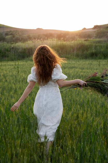 Foto gratuita mujer con ramo de flores vista trasera