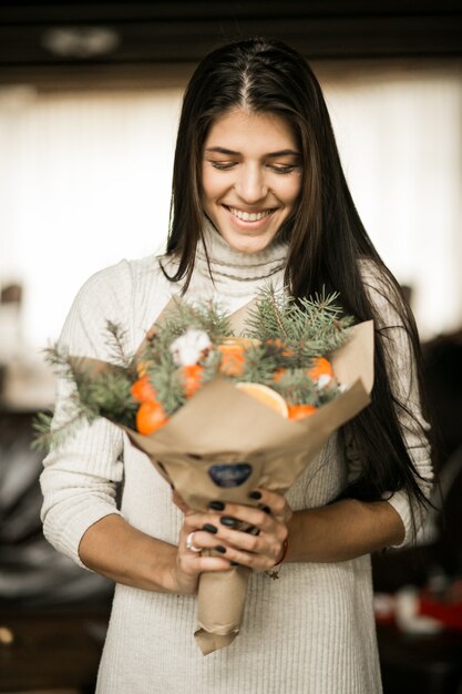 Mujer con un ramo de frutas en Navidad