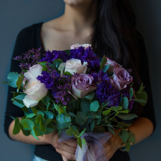 Mujer con ramo de rosas púrpuras, blancas