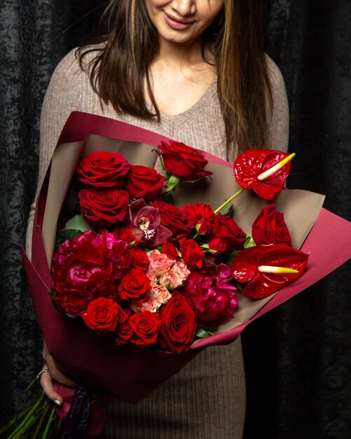 mujer con ramo de rosas rosas y rojas rosas y flores de peonía