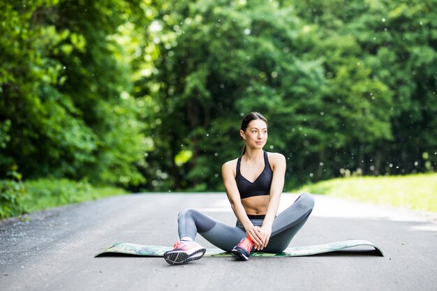 Mujer realiza estiramientos antes de hacer deporte en el parque al aire libre