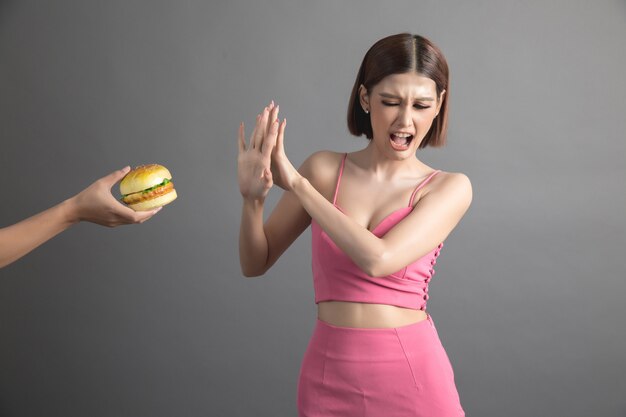 La mujer rechaza la comida chatarra y prefiere la comida sana.