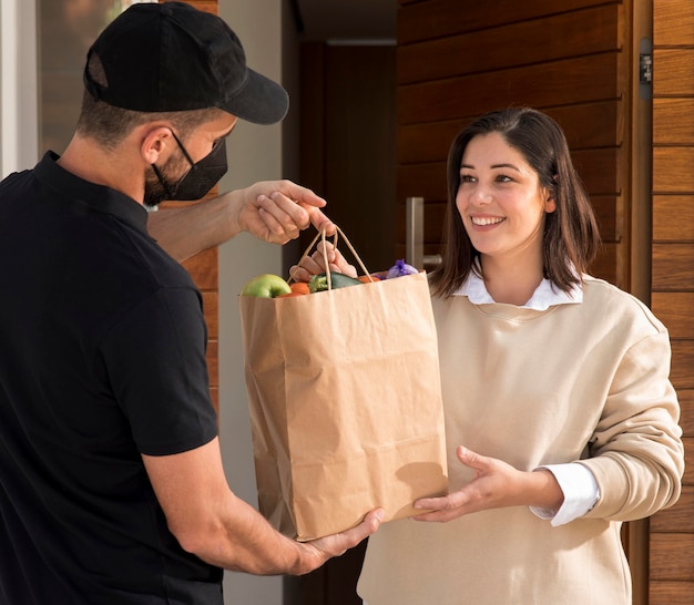 Mujer recibiendo una bolsa de comida entregada