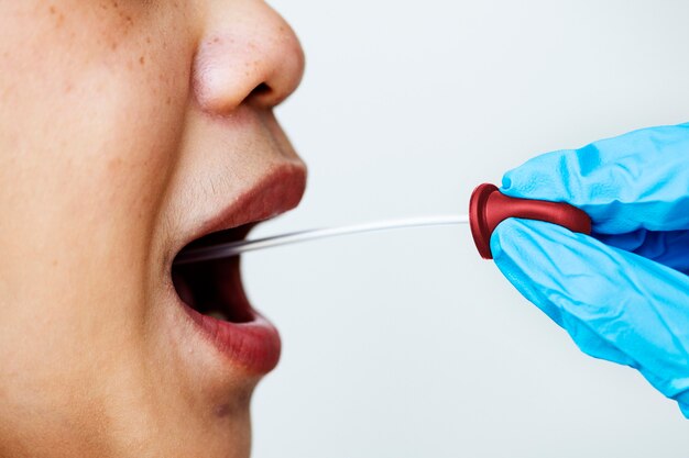 Mujer recibiendo un hisopo bucal para detectar coronavirus