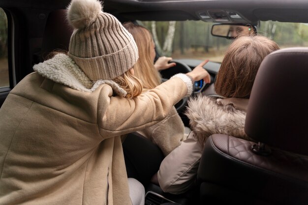 Mujer recibiendo indicaciones de su amiga mientras conduce el auto