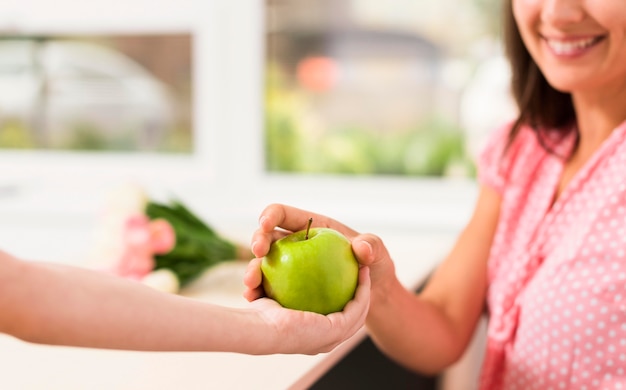 Mujer recibiendo una manzana de un niño