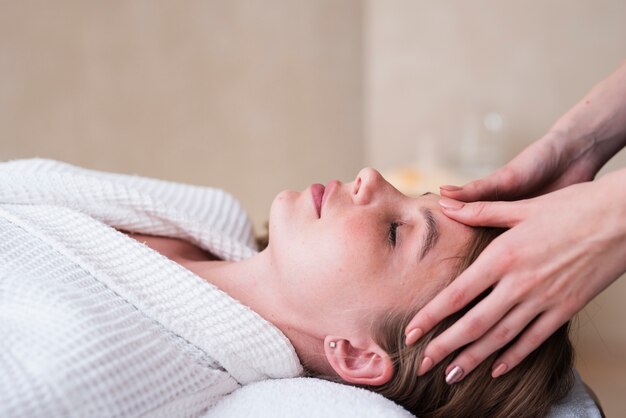Mujer recibiendo masaje de cabeza en el spa