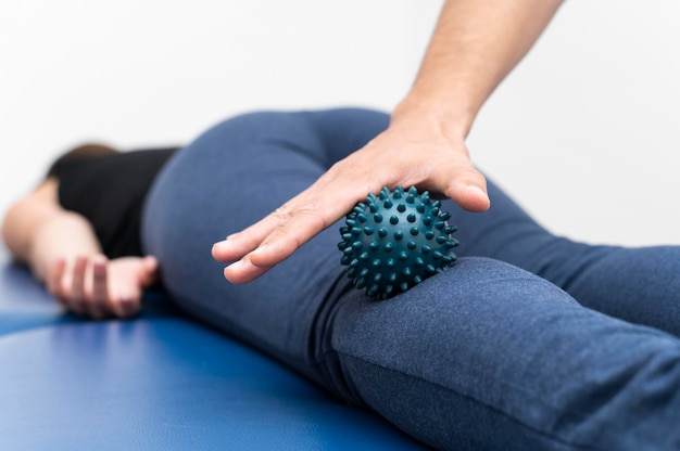 Mujer recibiendo masaje de fisioterapeuta con bola