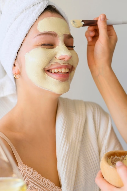 Foto gratuita mujer recibiendo una mascarilla en casa