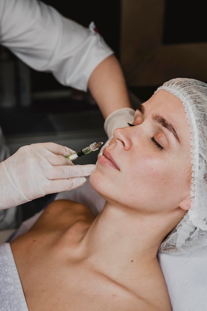 Foto gratuita mujer recibiendo un tratamiento de belleza facial en el spa