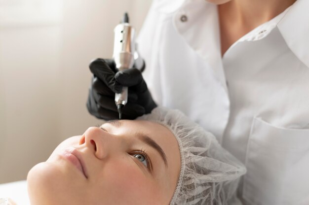 Mujer recibiendo un tratamiento de cejas en el salón de belleza