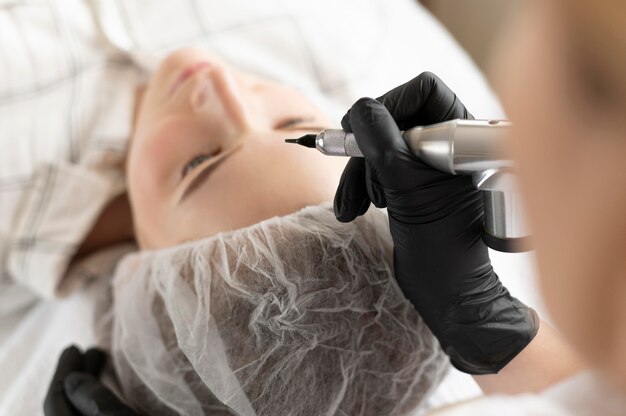 Mujer recibiendo un tratamiento de cejas en el salón de belleza