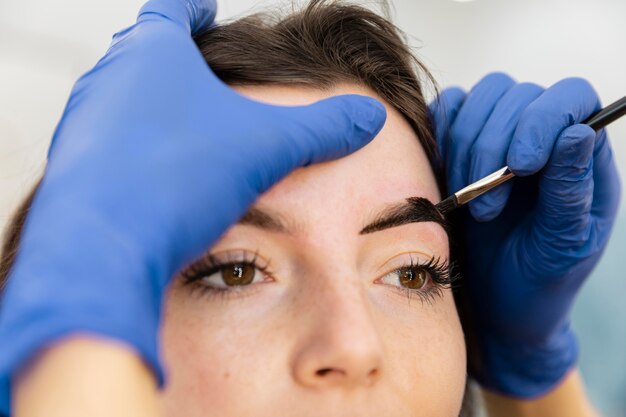 Mujer recibiendo un tratamiento de cejas en un salón de belleza