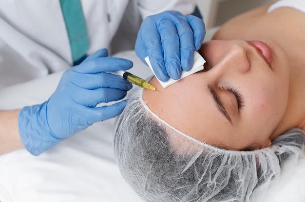 Mujer recibiendo tratamiento facial prp ángulo alto
