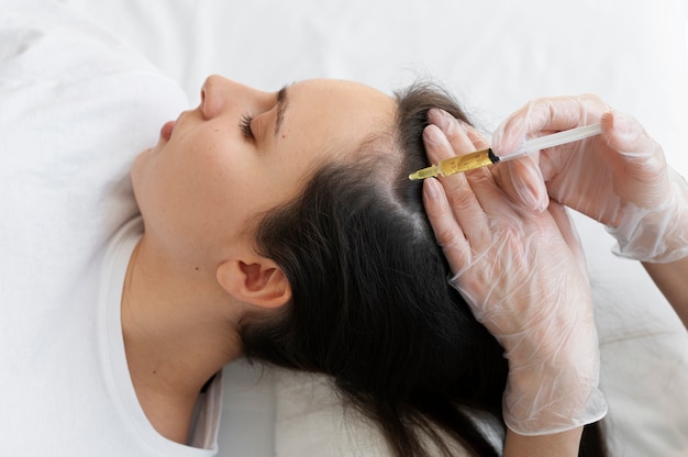 Mujer recibiendo tratamiento prp del cuero cabelludo ángulo alto