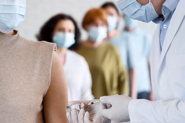 Mujer recibiendo vacuna inyectada por médico masculino