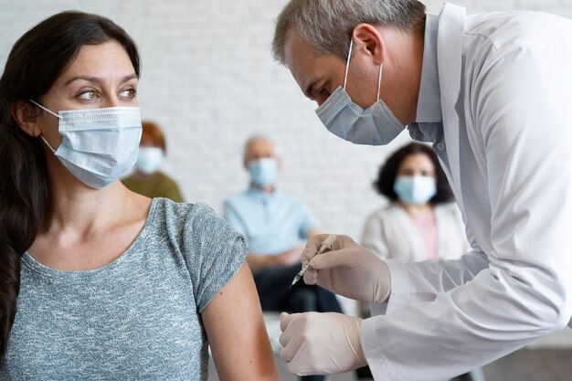 Mujer recibiendo vacuna inyectada por médico